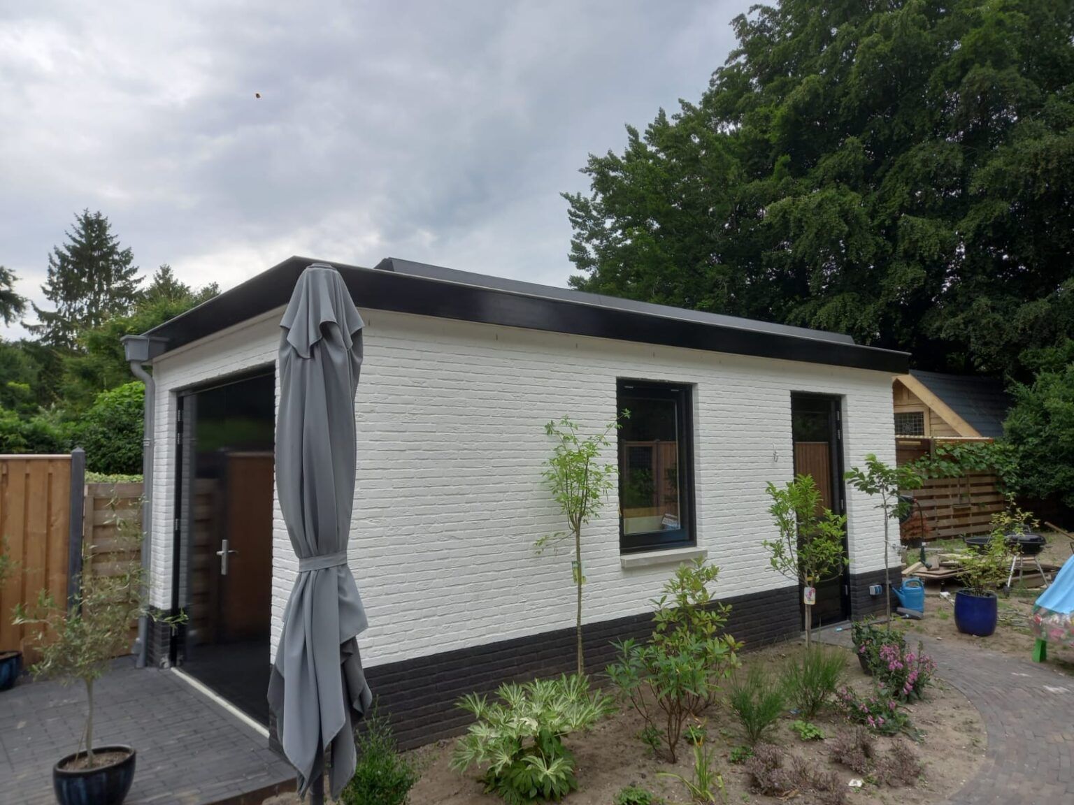 Wit tuinhuis met zwarte plint