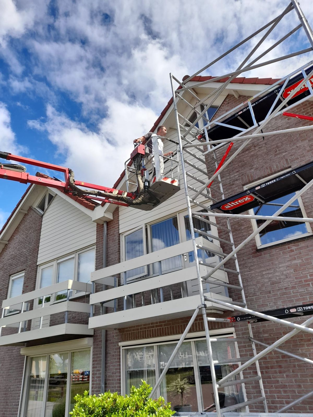 Steiger en hoogwerker bij een woning met balkons