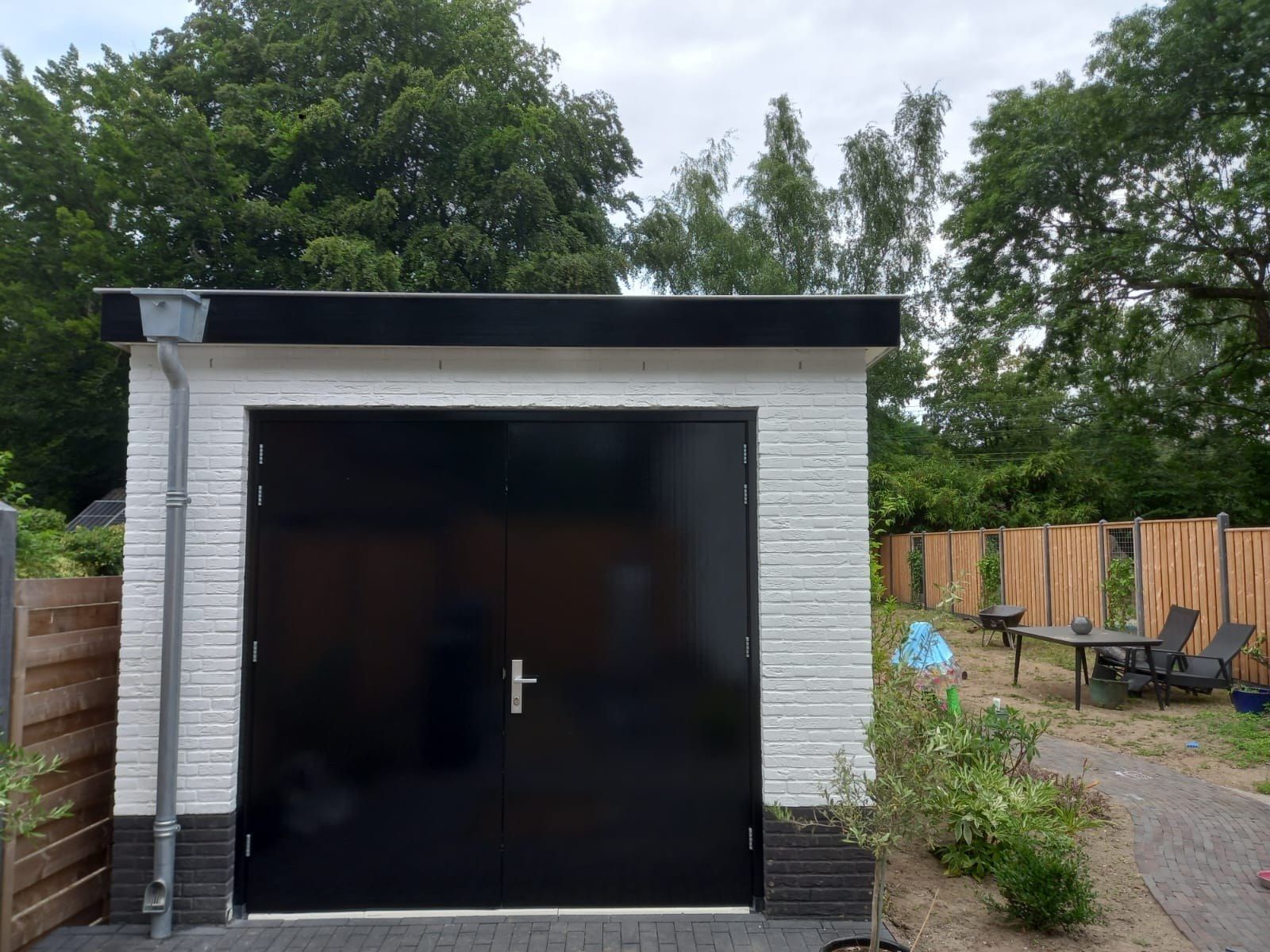 Witte garage met zwarte dubbele deuren