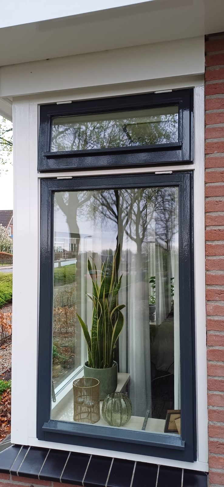 Hoog antraciet raamkozijn in een witte dagkant
