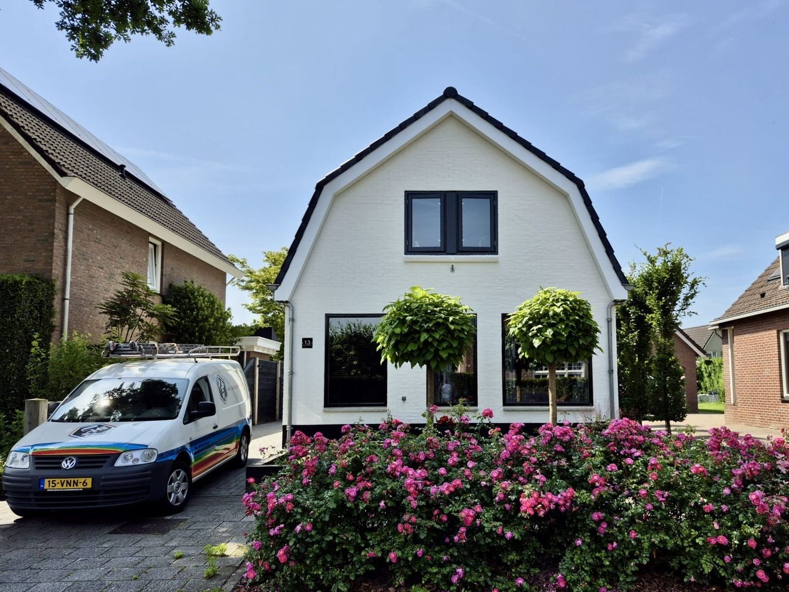 Witte woning met de bus van MZ Schilderwerken op de oprit